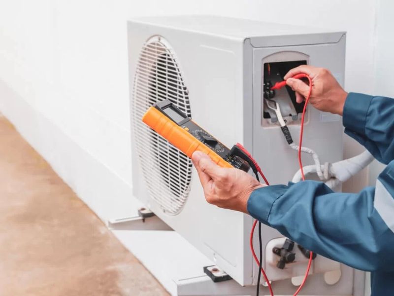 Technician servicing an outdoor air conditioner